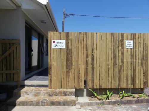 a wooden fence with a sign on it at Rose and Ale Self Catering Units in Gonubie