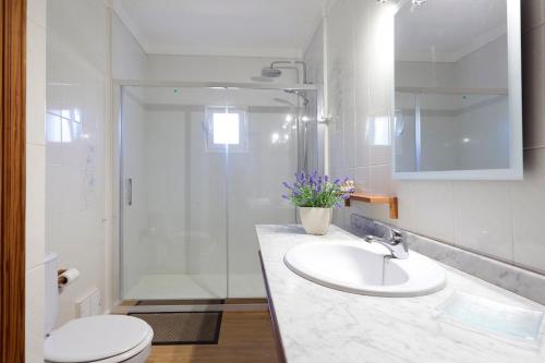 a bathroom with a sink and a shower and a toilet at Can Venzala in Pollença