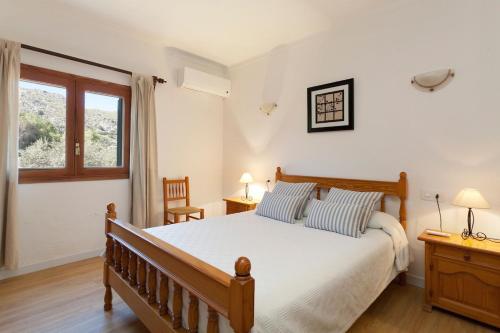 a bedroom with a large bed and a window at Can Venzala in Pollença