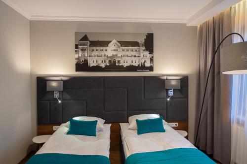 sypialnia z dwoma łóżkami i zdjęciem budynku w obiekcie Hotel Topaz Poznań Centrum w Poznaniu