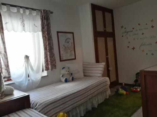 a childs bedroom with a bed and a window at Le Coeur du Pont in Donnas