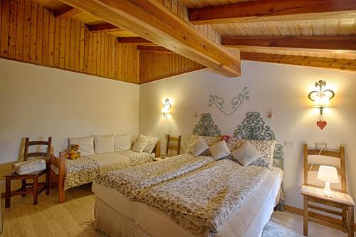a bedroom with two beds in a room with wooden ceilings at Le Coeur du Pont in Donnas