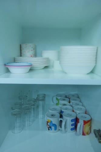 a shelf filled with cups and plates and bowls at Summer Sense Sattahip Pool Villa in Sattahip