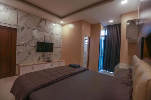 a bedroom with a large bed and a television at Summer Sense Sattahip Pool Villa in Sattahip