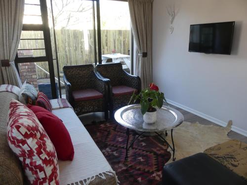 a living room with a couch and a table at Rose and Ale Self Catering Units in Gonubie