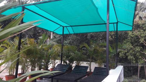 a group of chairs under a blue umbrella at Jeevan Homestay & Ayurvedic Yoga Retreat in Kovalam
