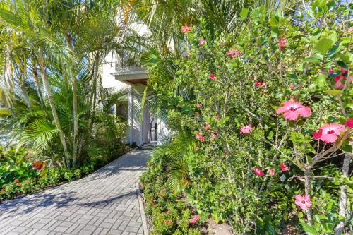 a walkway in front of a house with pink flowers at Pousada Ilha Faceira in Florianópolis