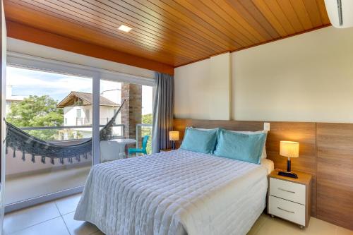 um quarto com uma cama e uma grande janela em Pousada Ilha Faceira em Florianópolis