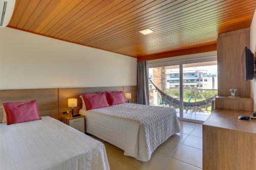 a hotel room with two beds and a large window at Pousada Ilha Faceira in Florianópolis