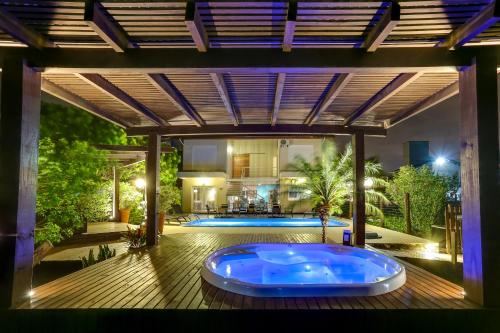 a large hot tub on a deck with a house at Pousada Ilha Faceira in Florianópolis