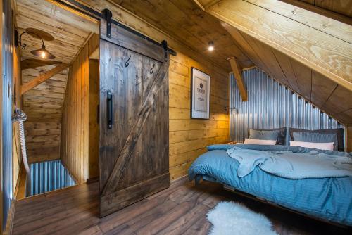 a bedroom with a barn door in a log cabin at Apartmany Calma in Liptovský Mikuláš