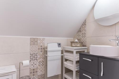 a bathroom with a sink and a toilet at Aux 3 nids fleuris in Irreville