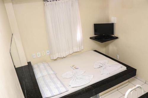 a bed in a small room with a window at Hotel Piramide Pernambués (Adults Only) in Salvador