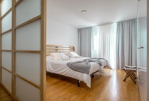 a bedroom with a bed and a sliding glass door at Market Place in Ponta Delgada