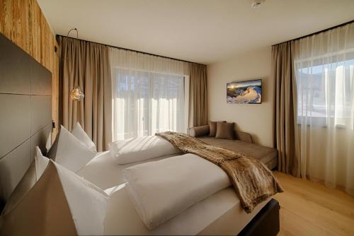 a bedroom with a large white bed in front of a window at K1 Mountain Chalet - Luxury Apartements in Brunico