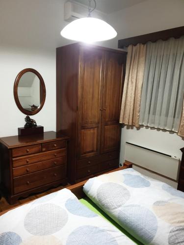 a bedroom with a bed and a dresser and a mirror at Terme Čatež Apartma Nine in Čatež ob Savi