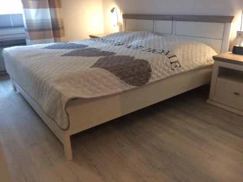 Bett in einem Schlafzimmer mit Holzboden in der Unterkunft Ferienwohnungen Kolsdorf B in Braunlage