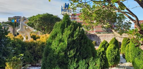 a garden with trees and a statue of a woman at Hotel Castillo de Gauzón in Salinas