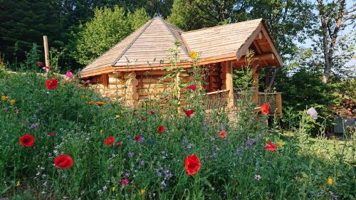 a small wooden cabin with a field of flowers at Les Cabanes Du Saleve in Collonges-sous-Salève