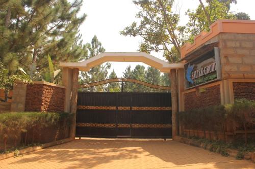 a gate in front of a building with a fence at Saltek Forest Cottages in Masindi