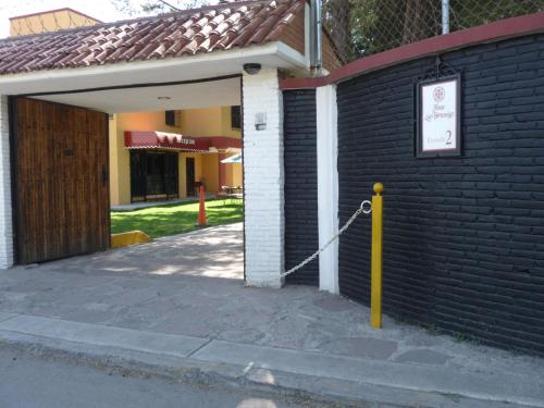 a door to a building with a yellow pole at Hotel Finca Las Hortensias in Tepotzotlán