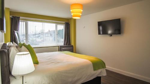 a bedroom with a bed and a tv on the wall at Ur City Pad - 4 bedrooms - 4 bathrooms - Somerset House in Birmingham