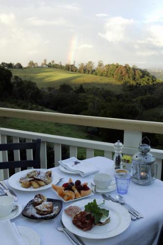 a table with plates of food on it with a view at The Spotted Chook and Amelie's Petite Maison in Montville