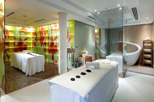 1 dormitorio con 1 cama grande y bañera en Exe Estepona Thalasso & Spa- Adults Only, en Estepona