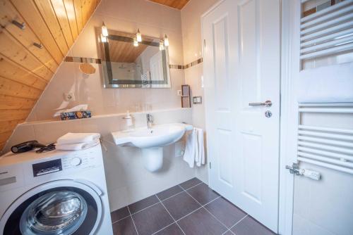 a bathroom with a washing machine and a sink at Ferienwohnungen Hofmann in Zingst