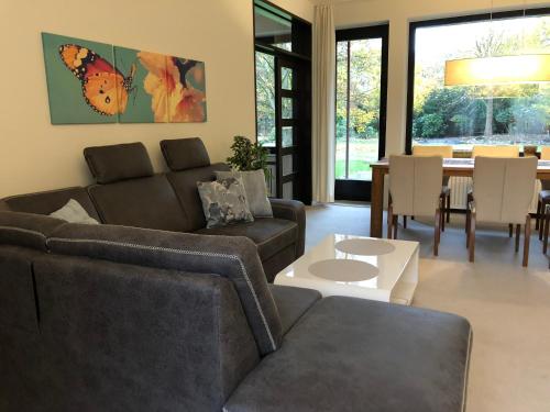 a living room with a couch and a table at Villa am Hülser Berg nähe Düsseldorf in Krefeld