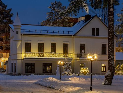 a large white house in the snow at night at BURMISTRO NAMAS in Druskininkai