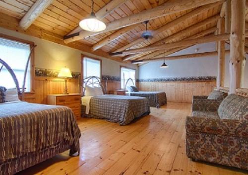 Habitación grande con 2 camas y sofá en The Smoke House Lodge, en Monteagle