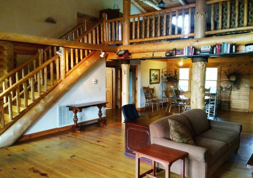 a living room with a couch and a staircase at The Smoke House Lodge in Monteagle