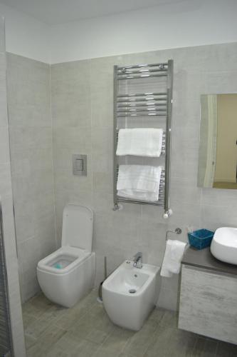 biała łazienka z umywalką, toaletą i umywalką w obiekcie Marina Guest Home w mieście Neapol