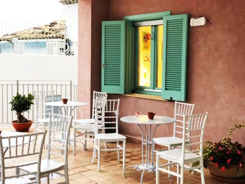 a patio with tables and chairs and a window at Borgo Rosso di Sera - Resort Country Chic in San Lucido