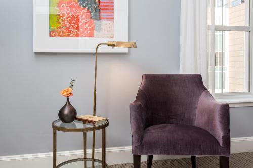 a purple chair sitting next to a table with a lamp at The Lancaster Hotel in Houston
