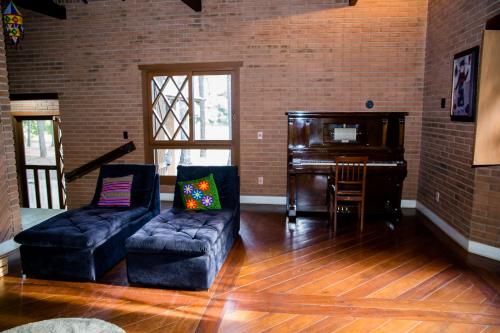 a living room with a couch and a piano at OM B&B + Spa in Viamão