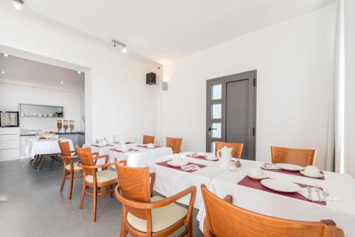 a dining room with white tables and chairs at Beach Guesthouse Mediteran in Podstrana