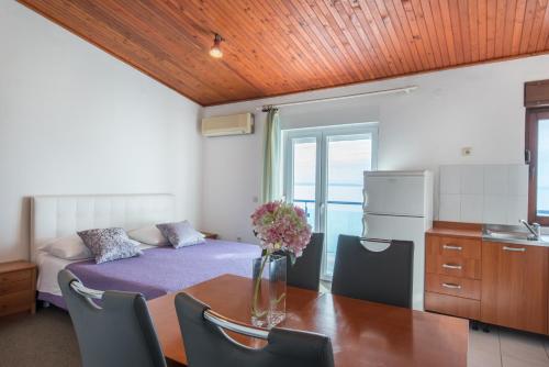 Zimmer mit einem Tisch und einem Bett sowie einer Küche in der Unterkunft Beach Guesthouse Mediteran in Podstrana