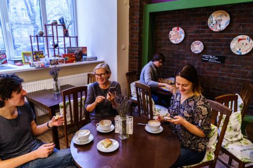 personas sentadas en una mesa en un restaurante mirando sus celulares en Hostel Croissant на Павелецкой, en Moscú