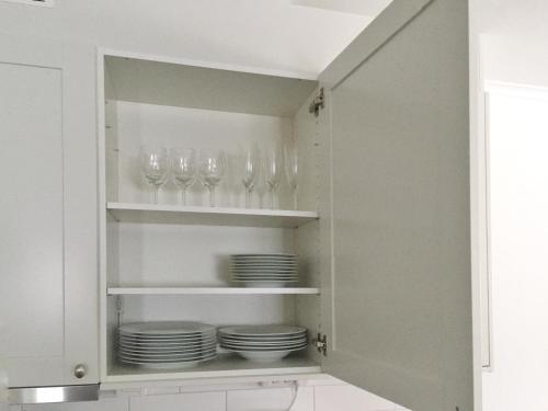 a cupboard with plates and wine glasses in it at VARIJLYAN in Sälen
