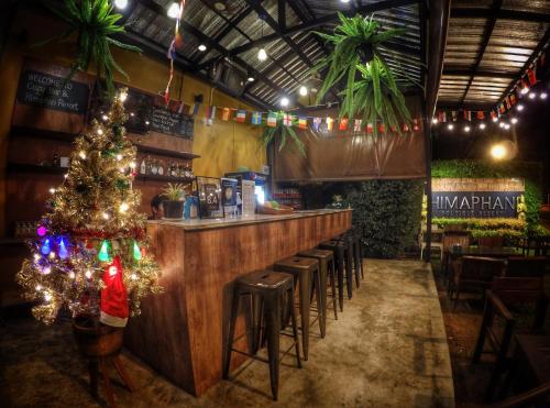 eine Bar mit einem Weihnachtsbaum und Stühlen in der Unterkunft Himaphan Boutique Resort - SHA EXTRA PLUS in Nai Yang Beach