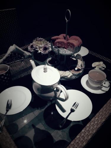 a table with plates and utensils on it at Agasthi Airport Close in Katunayake