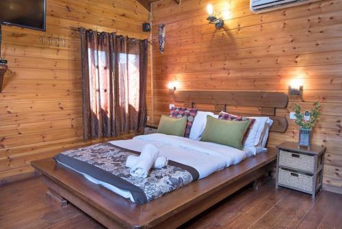 a bedroom with a large bed in a log cabin at Bikta Baglil in Shomera