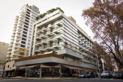 un edificio blanco alto con coches estacionados frente a él en Cozy High End Studio in heart of Palermo Soho -T105- en Buenos Aires