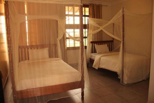 a bedroom with two beds and a window at Motel Tuku Masindi in Masindi