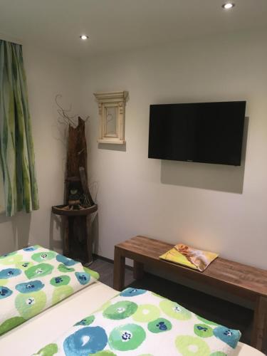 a room with two beds and a flat screen tv on the wall at Haus Gsenger in Abtenau
