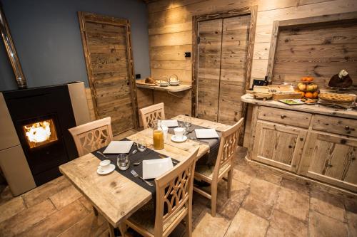 ein Esszimmer mit Tisch und Kamin in der Unterkunft Alpine Rooms Guesthouse in Breuil-Cervinia