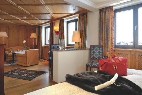 a bedroom with a bed with a red bag on it at Hotel Zürserhof in Zürs am Arlberg