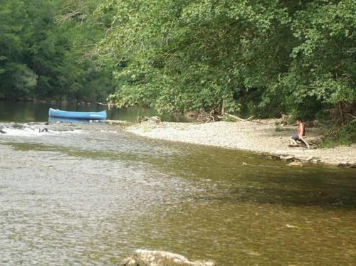 Un hombre caminando por la playa junto a un río en Vacation House Spiritus Flumine en Netretić